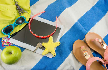 Summer accessories on beach towel top view