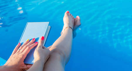 Girl reading by the swimming pool. Summer literatureの写真素材