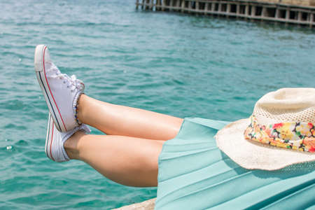 Woman legs above water on a dock, summer relaxの写真素材