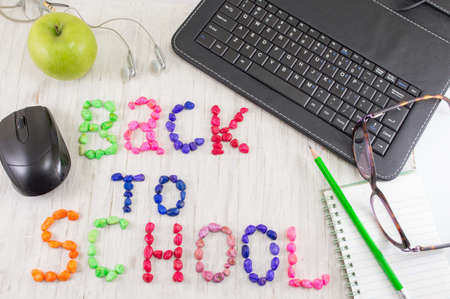 Back to school written with colorful stones and learning tools