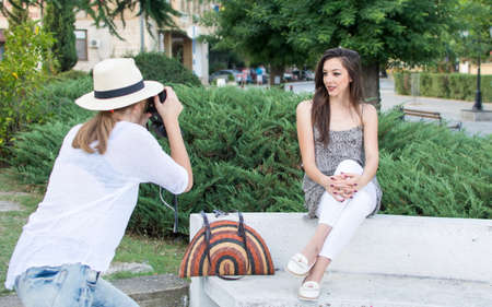 Two friends taking pictures in the parkの写真素材