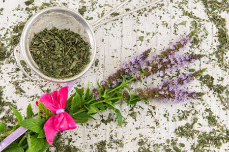 Mint tea herbs with flowers on a wooden tableの写真素材