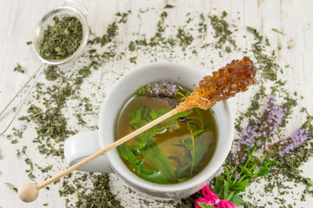 Mint tea with fresh herbs in a teacup