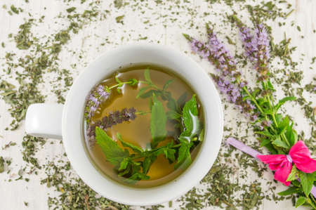 Mint tea with fresh herbs in a teacup