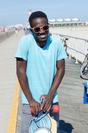 Young African American man holding his skateboardの写真素材