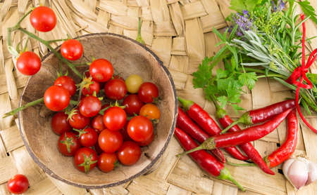 Red peppers and fresh cherry tomato on wooden backgroundの写真素材