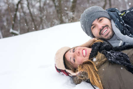 Crazy couple having fun in a snow covered parkの写真素材
