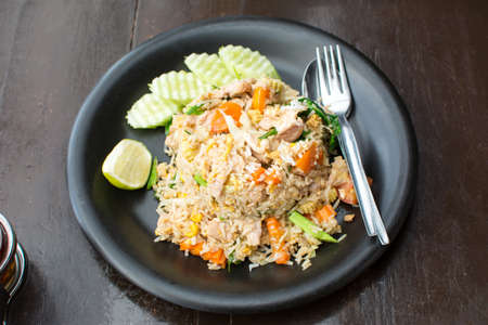 Fried rice with meat and vegetables served on a plateの写真素材