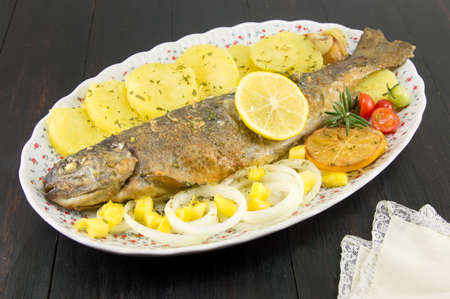 seasoned roasted trout served on a plate with potato salad