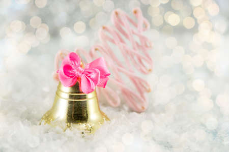 Christmas golden toy bell decoration with festive lightsの写真素材