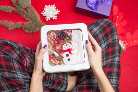 hands holding a gift box filled with candy canes