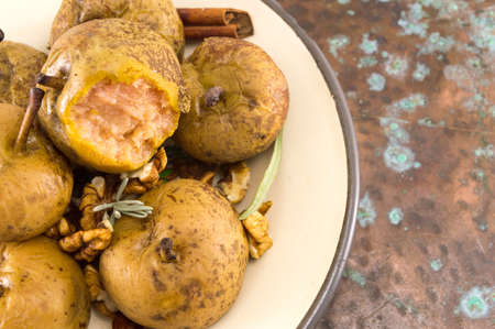 boiled wild pears with walnuts and cinnamon on a plateの写真素材