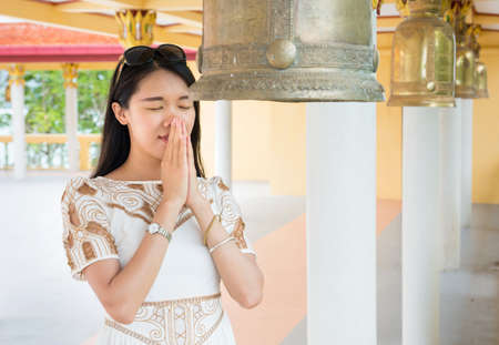 Young buddhist girl praying inside the templeの写真素材