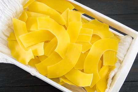 homemade uncooked pasta in a white wooden crateの写真素材