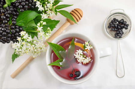 Cup of fresh elderberry tea with berries and honeyの写真素材