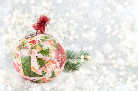 decoupage Christmas ball on a snowy surface with a big snowflakeの写真素材