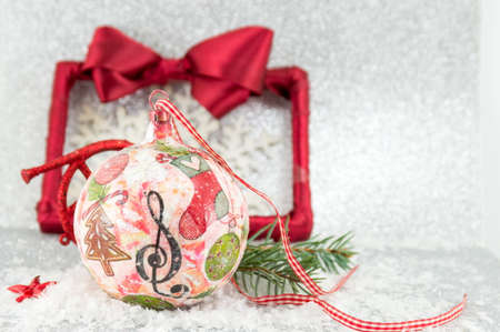 decoupage Christmas ball on a snowy surface with a picture frameの写真素材