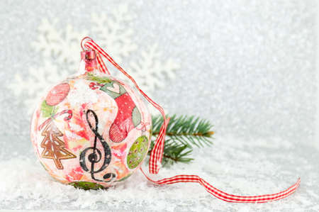 decoupage Christmas ball on a snowy surface with a big snowflakeの写真素材