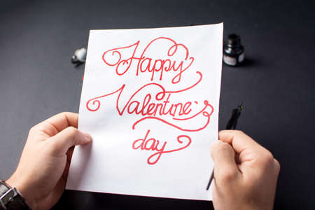 Man writing a Valentines day card calligraphyの写真素材