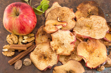 dried apples fresh apples walnuts and cinnamonの写真素材