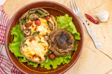 egg stuffed mushrooms on a brown plate with cherry tomatoesの写真素材