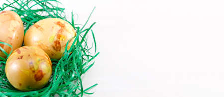 Painted Easter eggs in green straw on a table