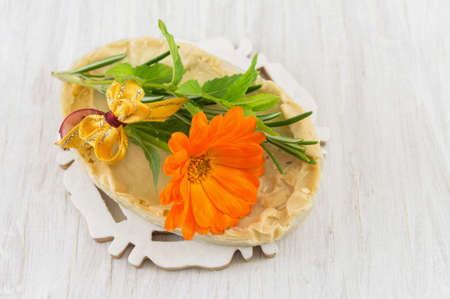 Herbal soap and an orange marigold flowerの写真素材
