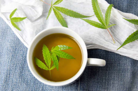 Cannabis tea and marijuana leaves top viewの写真素材