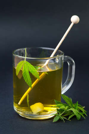 Marijuana herbal tea and green cannabis leavesの写真素材