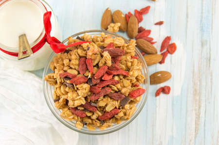 Granola muesli cereals with dried fruit in a bowl with milkの写真素材