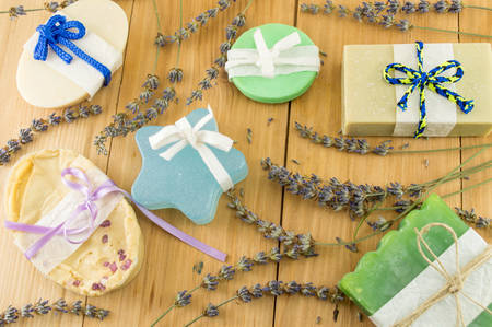 colorful handmade soaps with ribbons on a wooden table