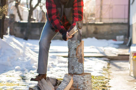 Man chopping firewood in the front yardの写真素材
