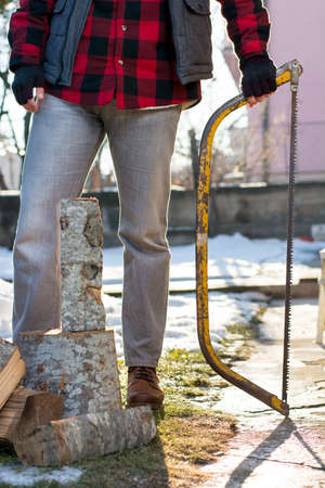 Man holding an axe for chopping firewood in the yardの写真素材