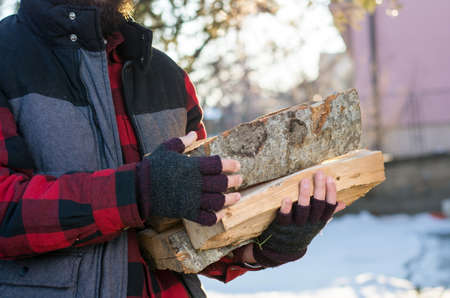 Man carrying firewood in the front yardの写真素材