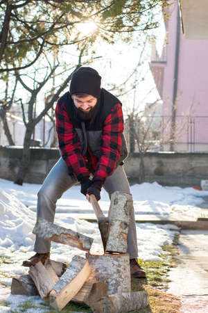 Man chopping firewood in the front yardの写真素材