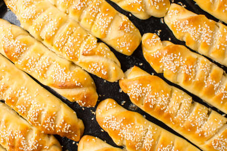 Homemade sesame pastry on black baking panの写真素材