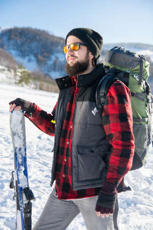 Bearded man with skis on the snowy mountainの写真素材
