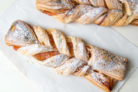 Braided sweet puff pastry sprinkled with poppy seedsの写真素材