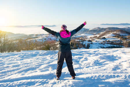 Hiker girl looking at the snowy mountains horizonの写真素材