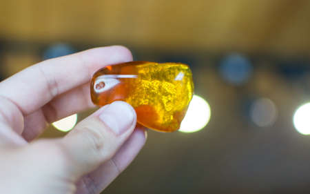 Hand holding an amber stone  in musum