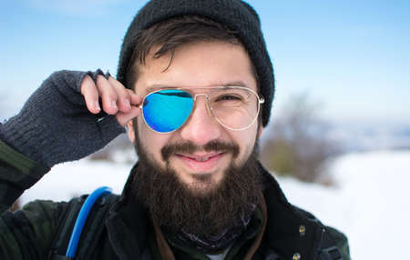 Happy bearded man with broken sunglasses outdoorsの写真素材