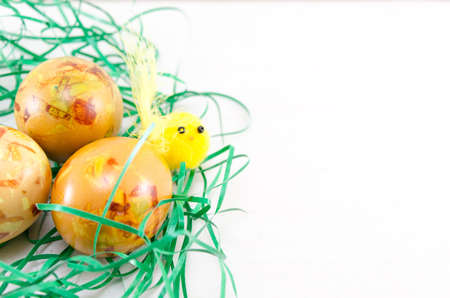 Decorated Easter eggs in green straw on a table