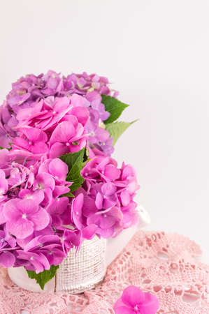 bunch of hortensia pink flowers in a vase on white backgroundの写真素材