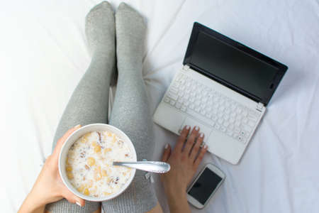 Woman eating cereals in bed top viewの写真素材