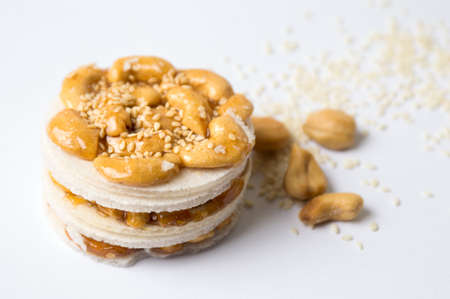 Cashew caramelised sweet snack with seeds on white