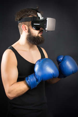 Bearded man with VR glasses standing in boxing guardの写真素材