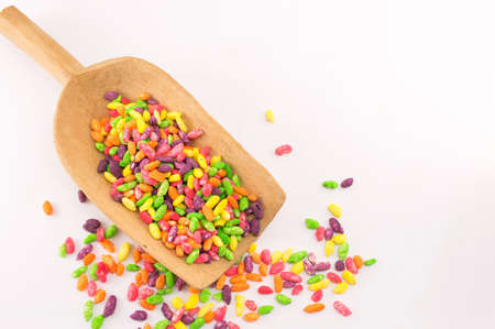 Colorful bonbons mix in a wooden spoonの写真素材