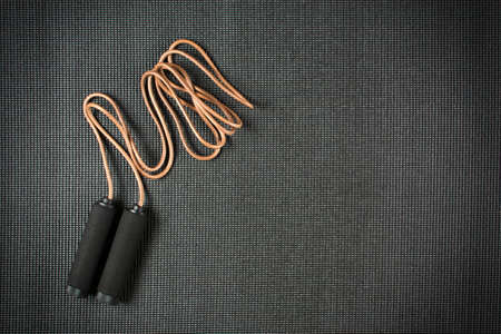 Leather jump rope on black yoga matの写真素材