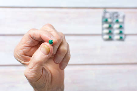 Senior woman hand holding a medical capsuleの写真素材