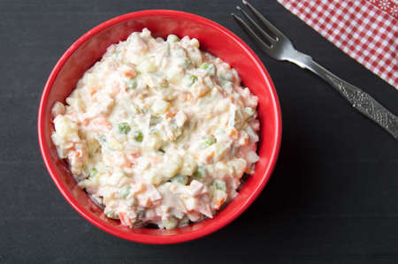 mixed vegetable salad with mayo in a red bowlの写真素材